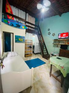 a bedroom with a large bed and a staircase at Íkaia Surf House in Ubatuba