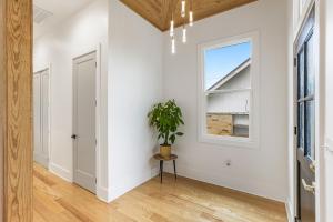 a hallway with white walls and a window and a potted plant at The Royal Haus NOLA 3 Bed Beauty in New Orleans