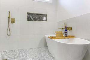 a white bathroom with a tub and a sink at The Royal Haus NOLA 3 Bed Beauty in New Orleans +15 photos