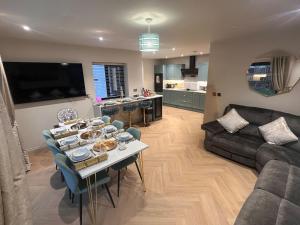 a living room with a table and a couch at Pistyll Ddu in Llanfairpwllgwyngyll
