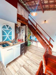 a kitchen with a spiral staircase in a house at Íkaia Surf House in Ubatuba