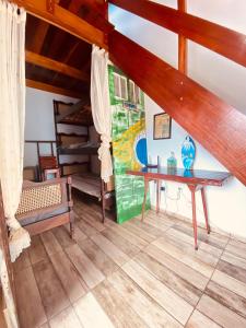 a room with a wooden table and a staircase at Íkaia Surf House in Ubatuba