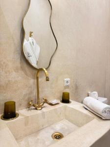 ein Badezimmer mit Waschbecken und Spiegel in der Unterkunft Riad Sumud in Marrakesch + 62 Fotos