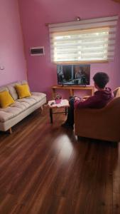 a man sitting on a couch in a living room at Canto del Bosque in Castro +6 photos
