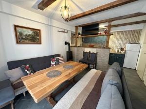 a living room with a wooden table and a couch at Vikendica Anja in Vlasic