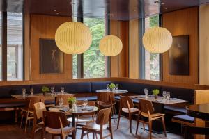 a dining room with tables and chairs and lights at Hotel AKA Boston Common in Boston