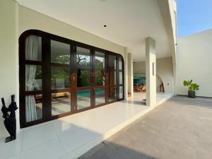an open hallway with glass doors and a patio at Nazeki Villa in Uluwatu
