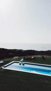 a swimming pool with a view of the ocean at PG - Beach House in Sintra