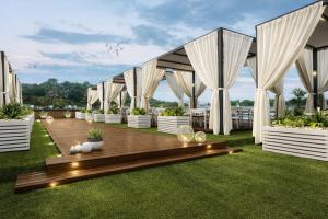 a patio with white drapes and a wooden deck at Five-Stars Deluxe River Kruz from Aswan to Luxor 3 Nights in Aswān