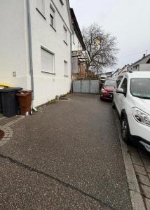 a parking lot with cars parked next to a building at S&G Home Stilvolles 2-Zimmer-Apartment in zentraler Lage, Komfort & Entspannung garantiert! in Ditzingen