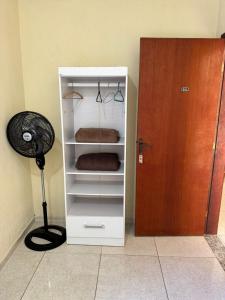 a white closet with a fan next to a door at POUSADA FÊNIX in Viçosa +6 photos