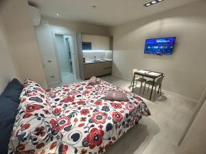 a bedroom with a bed with a red and white comforter at CARPI SUITE - Appartamenti Minghetti in Carpi