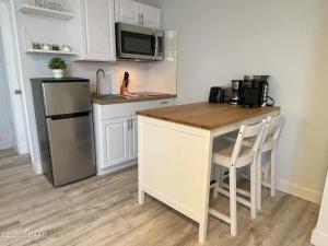 a small kitchen with a counter and a refrigerator at Beach Front Resort with Ocean View in Daytona Beach