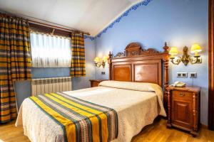 a bedroom with a bed with a wooden head board at Hotel del Pastor in Morella
