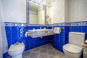 a blue tiled bathroom with a toilet and a sink at Hotel del Pastor in Morella +20 photos