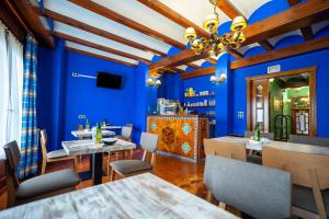 a restaurant with blue walls and tables and chairs at Hotel del Pastor in Morella