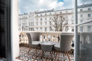 a balcony with chairs and a table and a building at MSK Elite in London