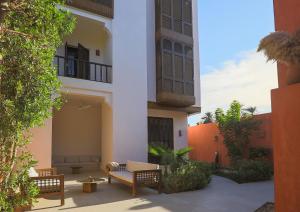 a courtyard of a building with chairs and tables at Al Wadi Hôtel in Al Aqālitah