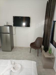 a room with a bed and a chair and a television at אלמוגי אוראל in Eilat