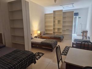 a room with two beds and a room with shelves at Flat Casa Grande in Itapira