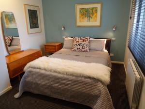 a bedroom with a bed with a white blanket at The Gallery Accommodation McCrae in McCrae