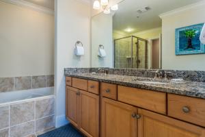 a bathroom with a double sink and a tub at Wave Watcher - Holiday Isle #609 in Dauphin Island
