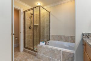 a bathroom with a shower and a bath tub at Wave Watcher - Holiday Isle #609 in Dauphin Island