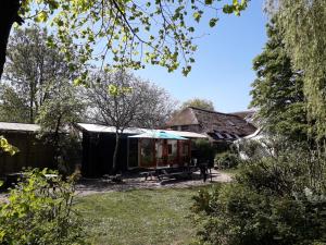 a house with a picnic table in a yard at Toplocatie voor je workshop! Of grote gezin! Zwembad! in Hurwenen