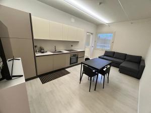 a kitchen and living room with a table and a couch at CARPI SUITE - Appartamenti Minghetti in Carpi