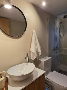 a bathroom with a sink and a toilet and a mirror at Pension Zoi Luxury Room in Kolymbia