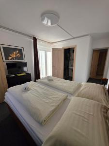 two large beds in a room with a television at Haus Piller in Bad Hofgastein