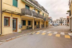 an empty street in a city with yellow buildings at Bilocale moderno a Conselve in Conselve