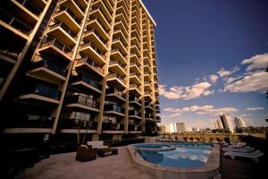 a large building with a swimming pool next to a building at Kubitschek Plaza Hotel - Flat Particular ALM in Brasília