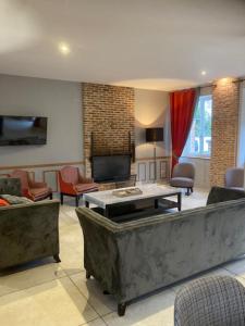 a living room with a couch and a tv at Gîte de la Crayère in Gionges