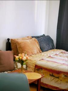 a room with a bed and a table with a vase of flowers at Secret Nest in Manila +15 photos