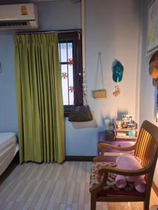 a bedroom with a green curtain and a chair at Budget Place Homestay-Solo Traveler in Ban Dan