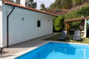 a backyard with a swimming pool and a house at Ermal Green Haven in Vieira do Minho