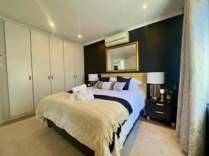 a bedroom with a large bed and a mirror at Sunset View in Durbanville