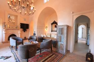 un soggiorno con letto e lampadario pendente di Villa Jannah a Marrakech