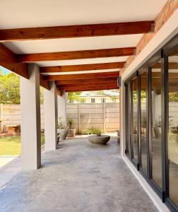 an outdoor patio with a wooden ceiling and glass doors at 10 on Sysie in Sedgefield