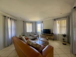 a living room with a couch and a tv at Sunset View in Durbanville