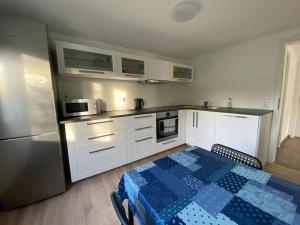 a kitchen with white cabinets and a table and a refrigerator at Burgweg Living in Bad Wildungen