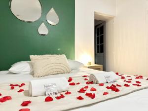 a bed with red roses laying on it at Le SPA Étoilé - Baignoire Balnéo et Sauna Privatif in Mont-de-Marsan