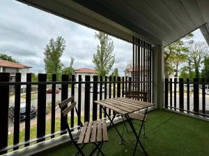 a picnic table and a chair on a porch at L'Émeraude - Proche Hôpital - Parking - Clim - Fibre - Terrasse in Mont-de-Marsan
