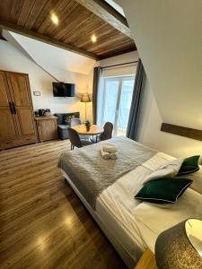 a bedroom with a large bed and a table in it at Willa Donia in Ustroń