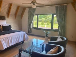 a bedroom with a bed and two chairs and a table at The Swiss Garden in Midrand +45 photos