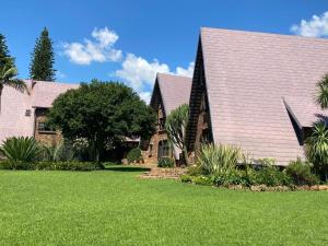 a house with a green lawn in front of it at The Swiss Garden in Midrand
