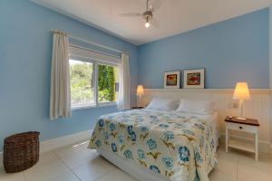 a blue bedroom with a bed and a window at Pousada Vila do Bosque in Bombinhas +113 photos