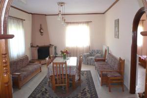 a living room with couches and a table and chairs at Γαλήνη in Konitsa