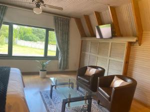 a bedroom with a bed and two chairs and a table at The Swiss Garden in Midrand